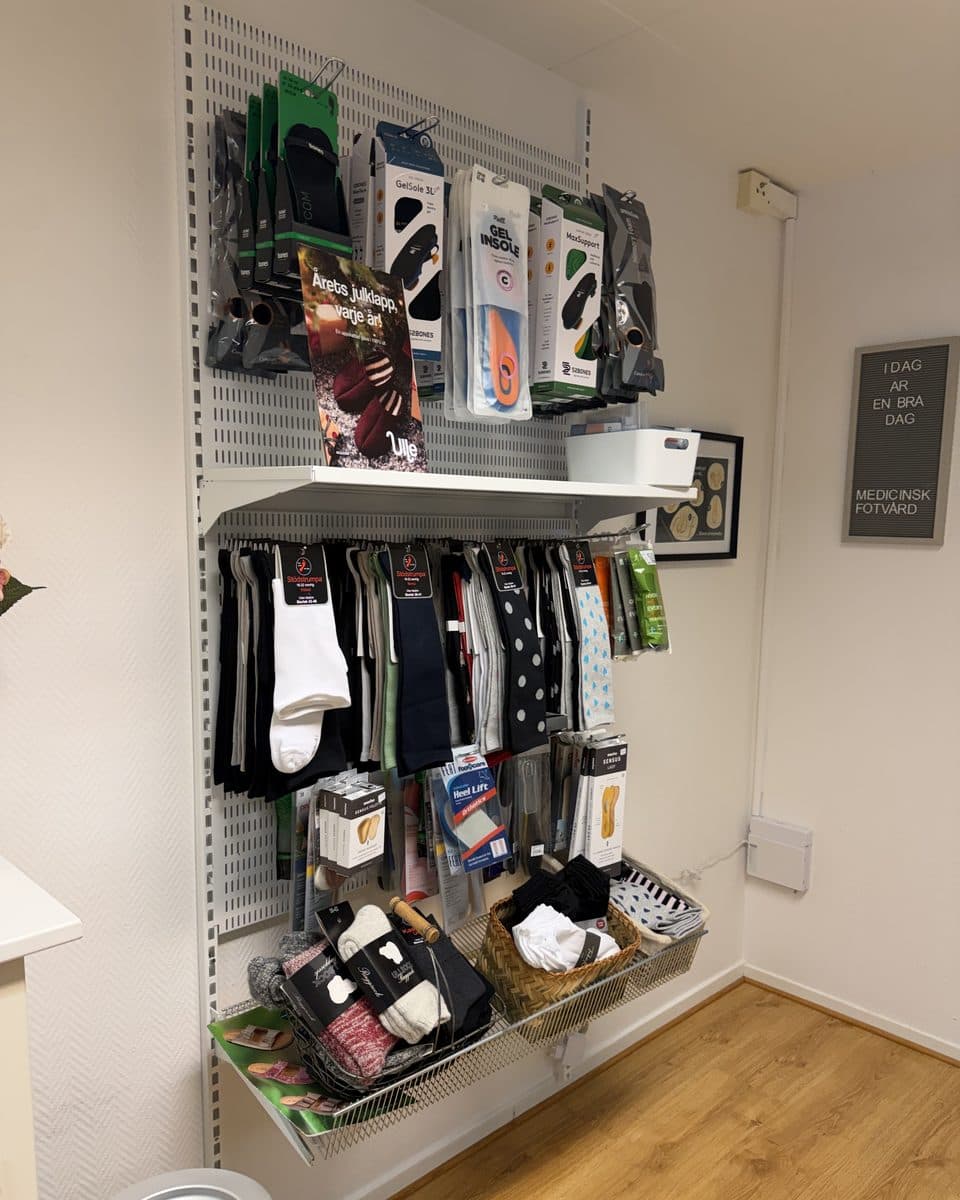 Butikshörnan i kliniken med ullstofflor, strumpor och en väntrumsstol